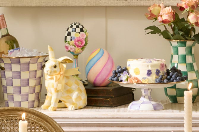 Easter-themed table setting with decorative eggs, rabbit figurine, and cake.