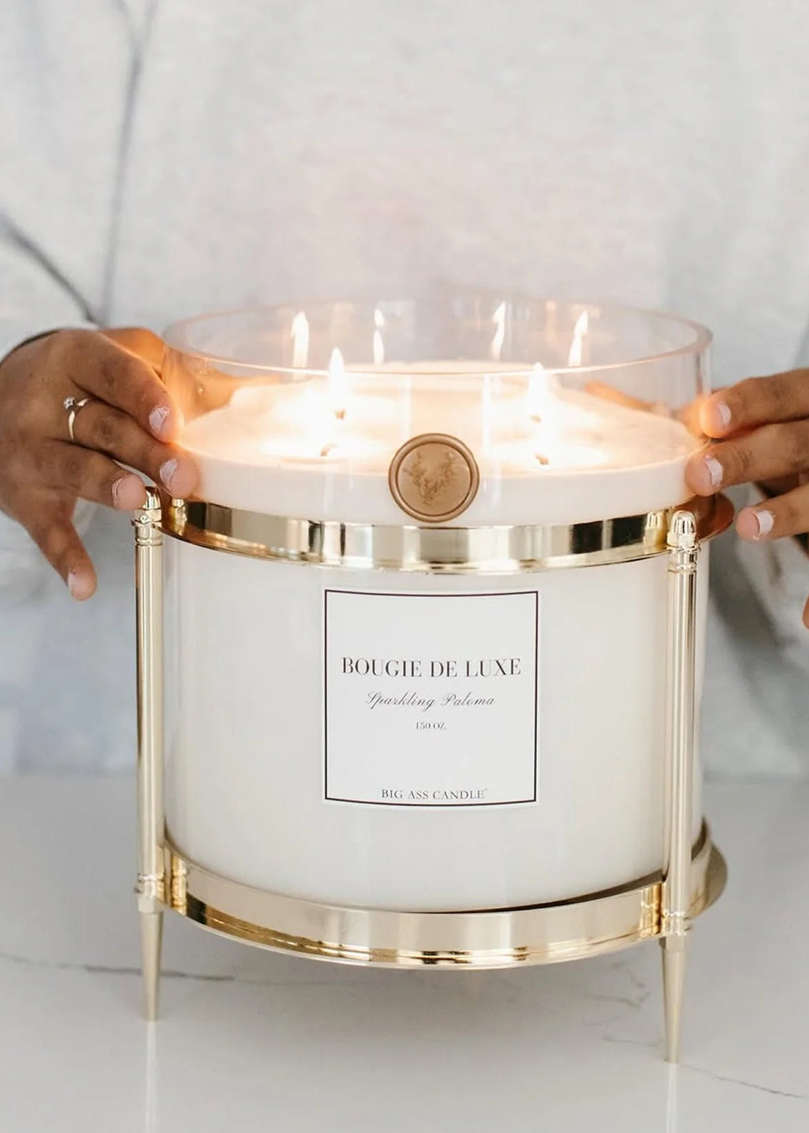 Bougie de Luxe candle held by a person on a white background